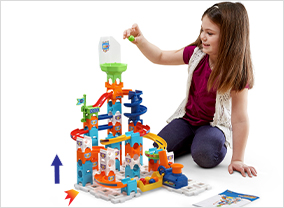 Child placing a marble into the funnel to see if tilting the set effects which side the marble rolls.